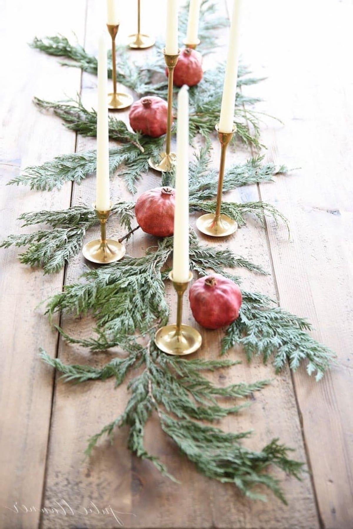 Ein festlicher Weihnachtstischläufer, geschmückt mit Granatäpfeln und Grünzeug, perfekt als festliches Kerzen-Mittelstück.