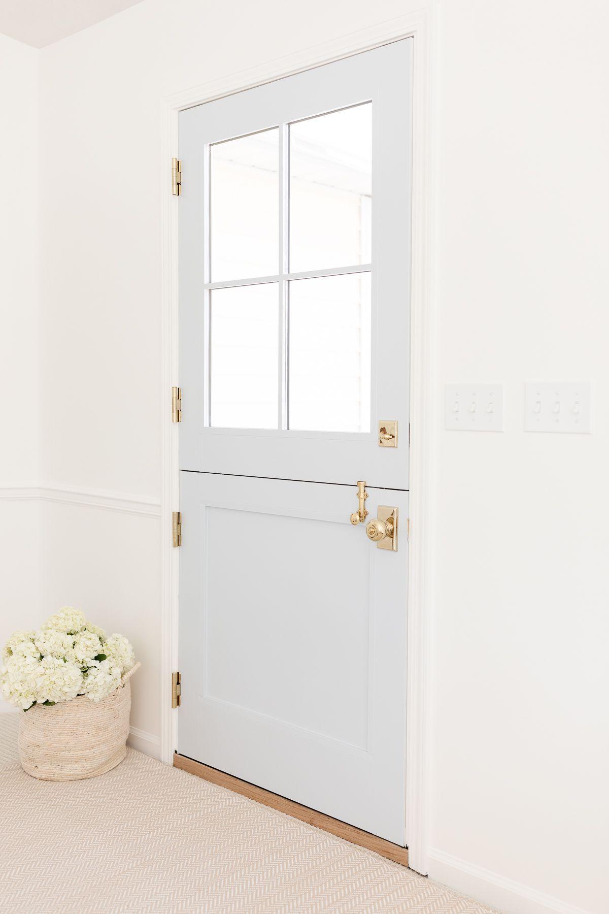 Benjamin Moore Einfach Weiß 5 Ein Eingangsbereich mit Simply White Wänden und einer blauen holländischen Tür.
