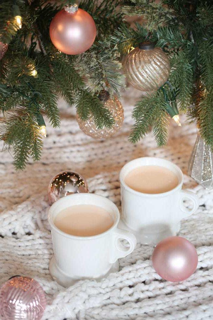 Fantasievolle rosafarbene heiße Schokolade, die Kinder lieben werden Rosafarbene heiße Schokolade in einer weißen Tasse unter einem Weihnachtsbaum.