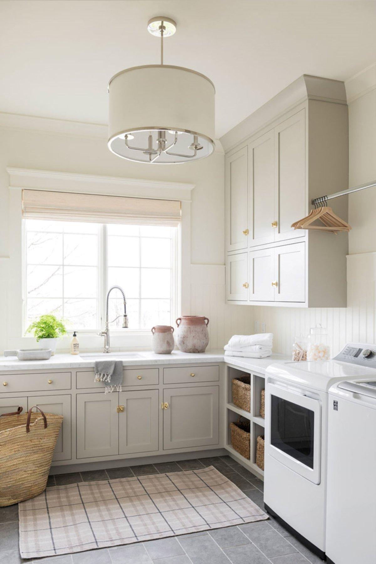 Benjamin Moore Revere Pewter 5 Eine Waschküche mit in Benjamin Moore Revere Pewter gestrichenen Schränken.