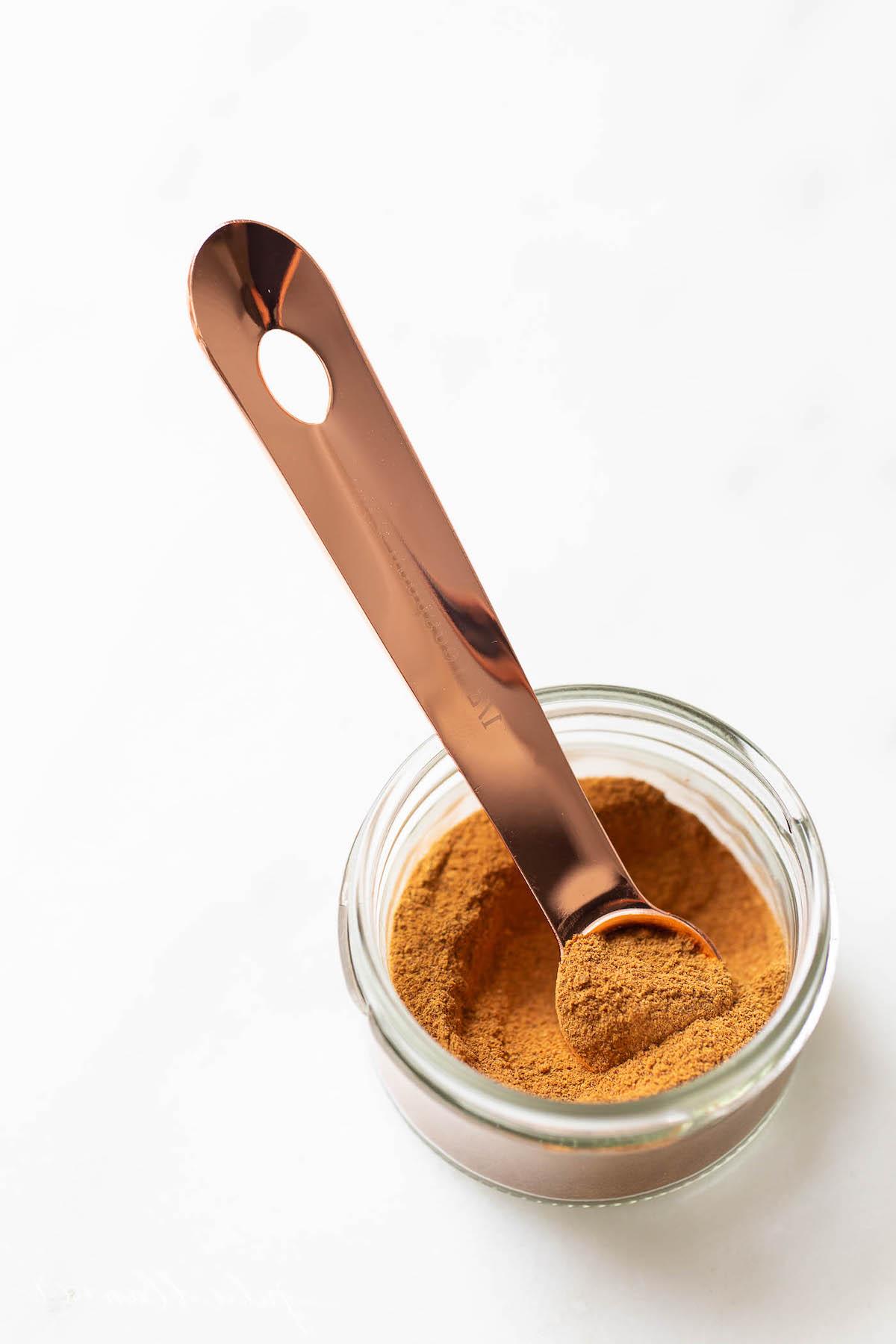 Kürbiskuchengewürz 5 Ein kleines, klares Glas mit Kürbiskuchengewürz auf einer weißen Arbeitsplatte.