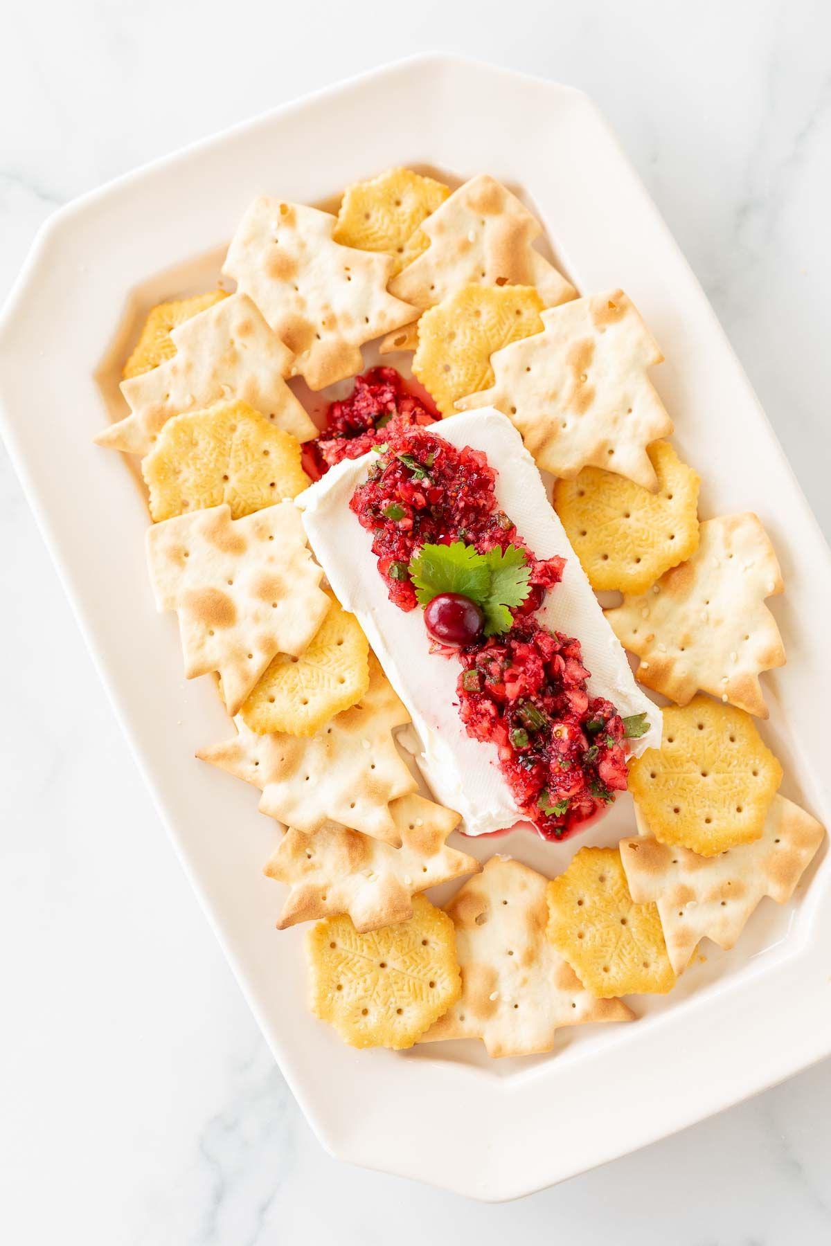Cranberry-Salsa 6 Ein Teller voller Cracker, die Cranberry-Salsa auf einem Block Frischkäse umgeben