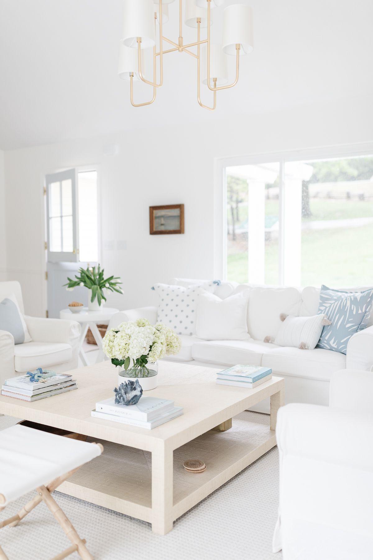 Abnehmbare Schonbezüge für Sofas 6 Ein helles, weißes Wohnzimmer mit einem weißen Hussofa und hellblauen Kissen