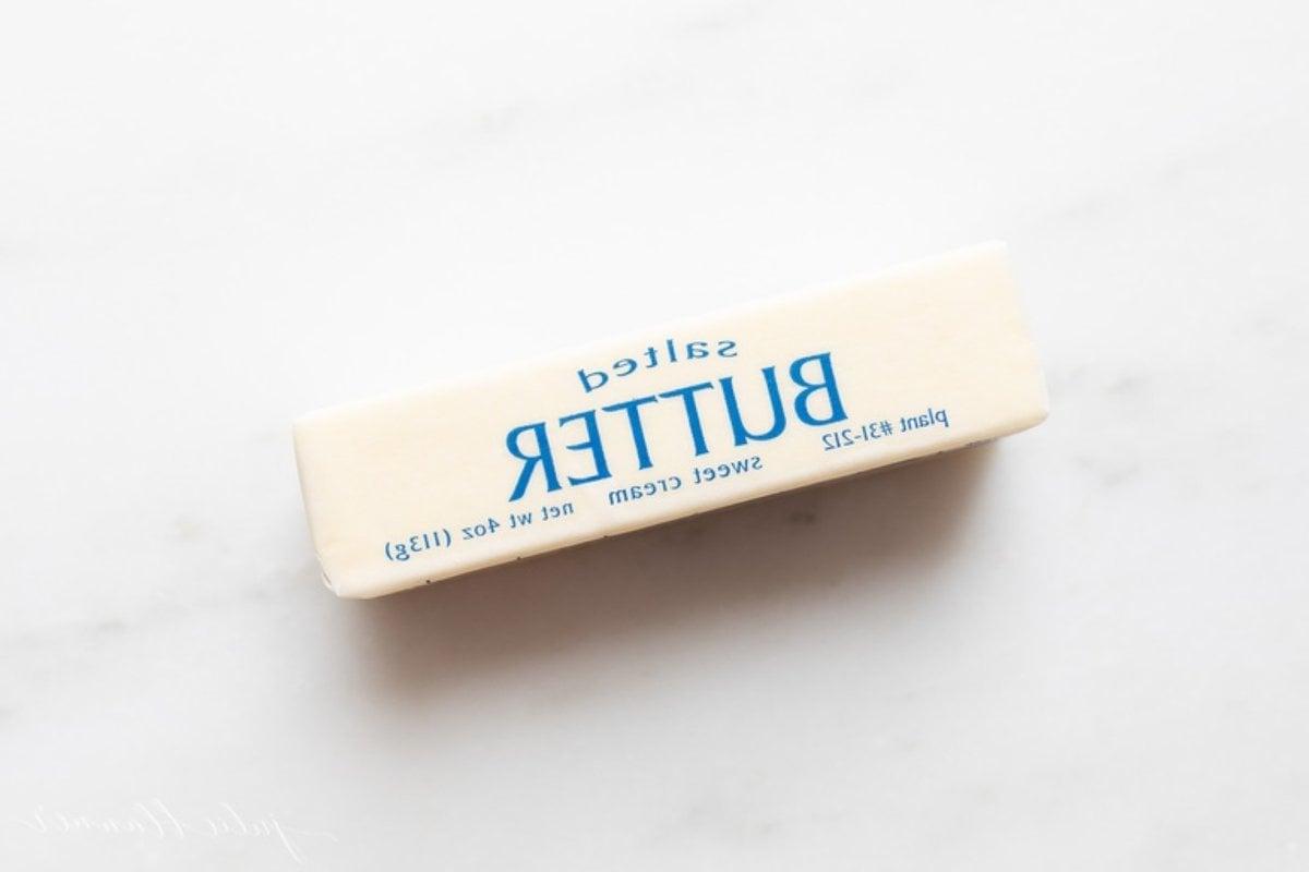 Ein einzelnes Stück gesalzene Butter auf einer Marmorarbeitsplatte.