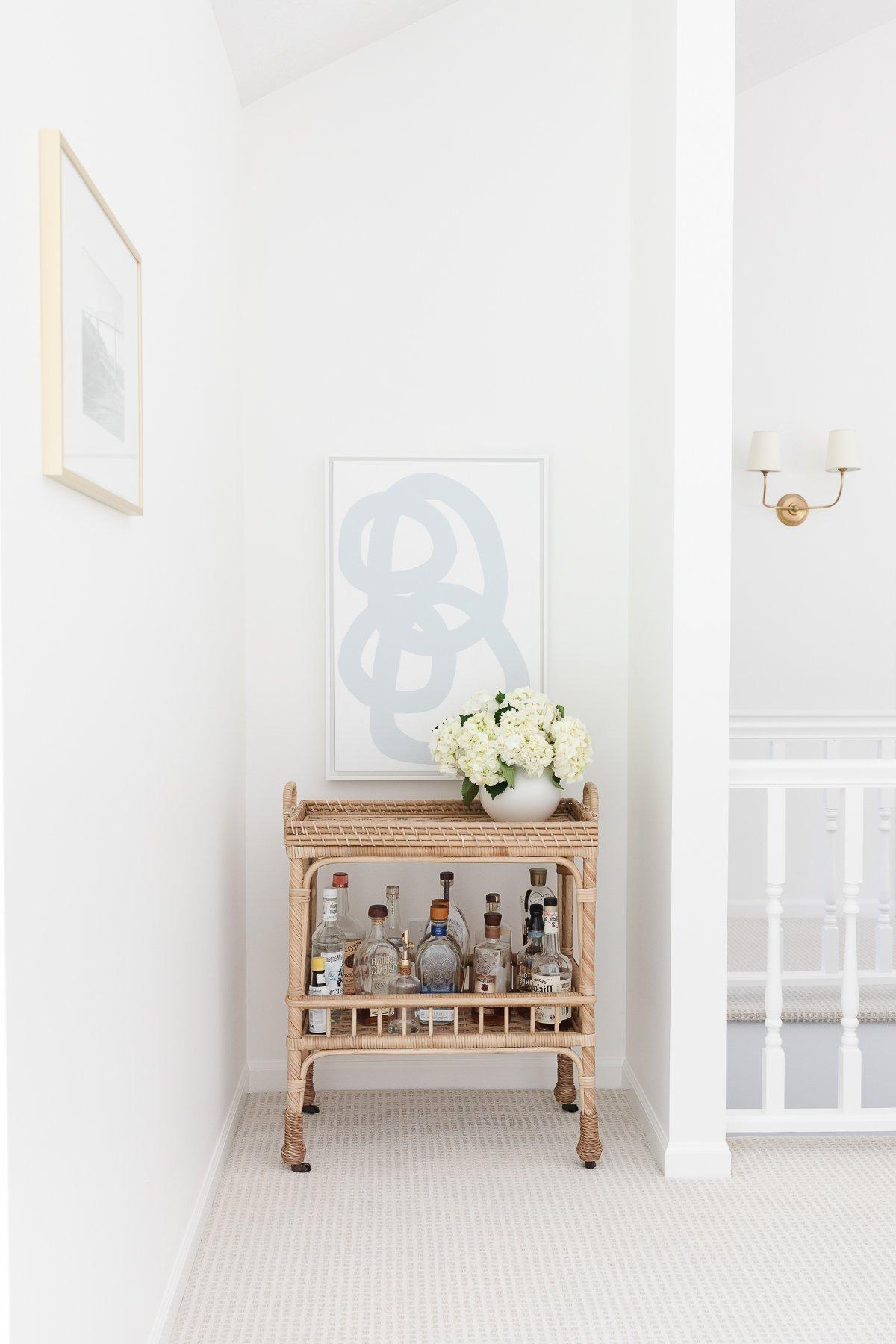 Benjamin Moore Einfach Weiß 6 Ein weißes Wohnzimmer mit blauen Akzenten, Wände gestrichen in Benjamin Moore Simply White.