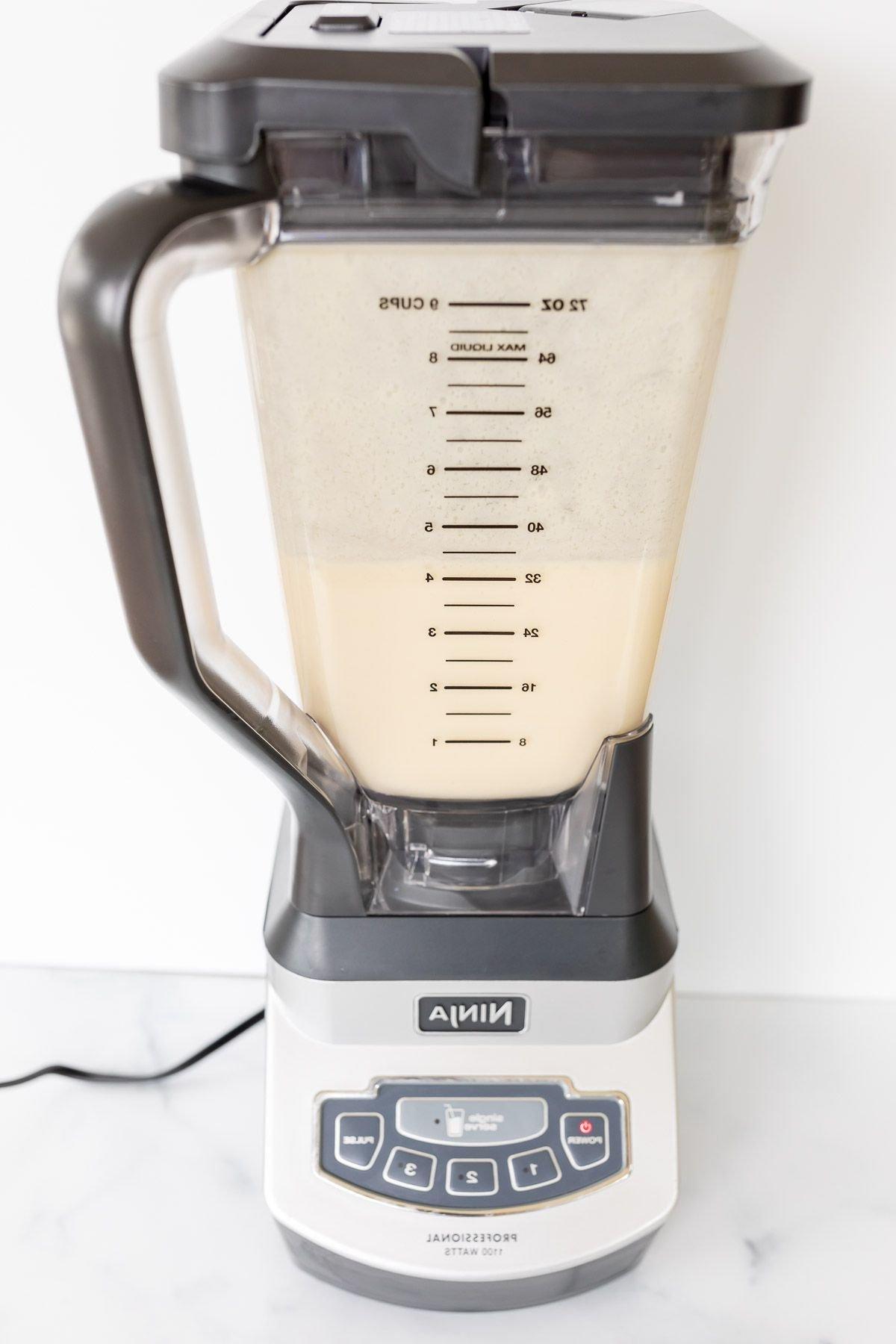 Orangensaft wird zur cremigen Orangen-Sherbet-Mischung in einem Ninja Blender hinzugefügt