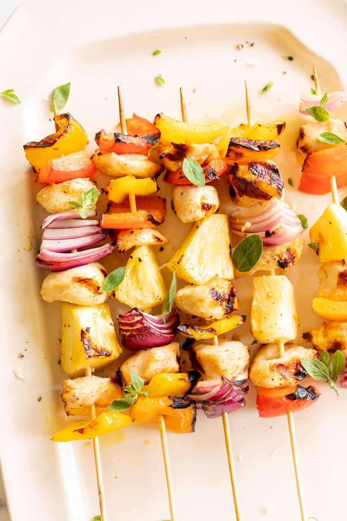 **Einfache Hähnchenspieße** 6 Gegrillte Hähnchenspieße auf einer weißen Platte