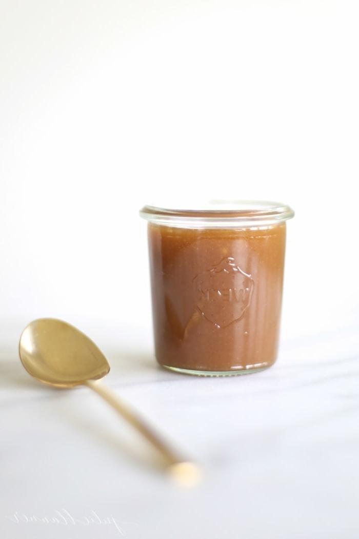 Gesalzene Karamellsoße 7 Gesalzene Karamellsauce in einem Glas neben einem Löffel.