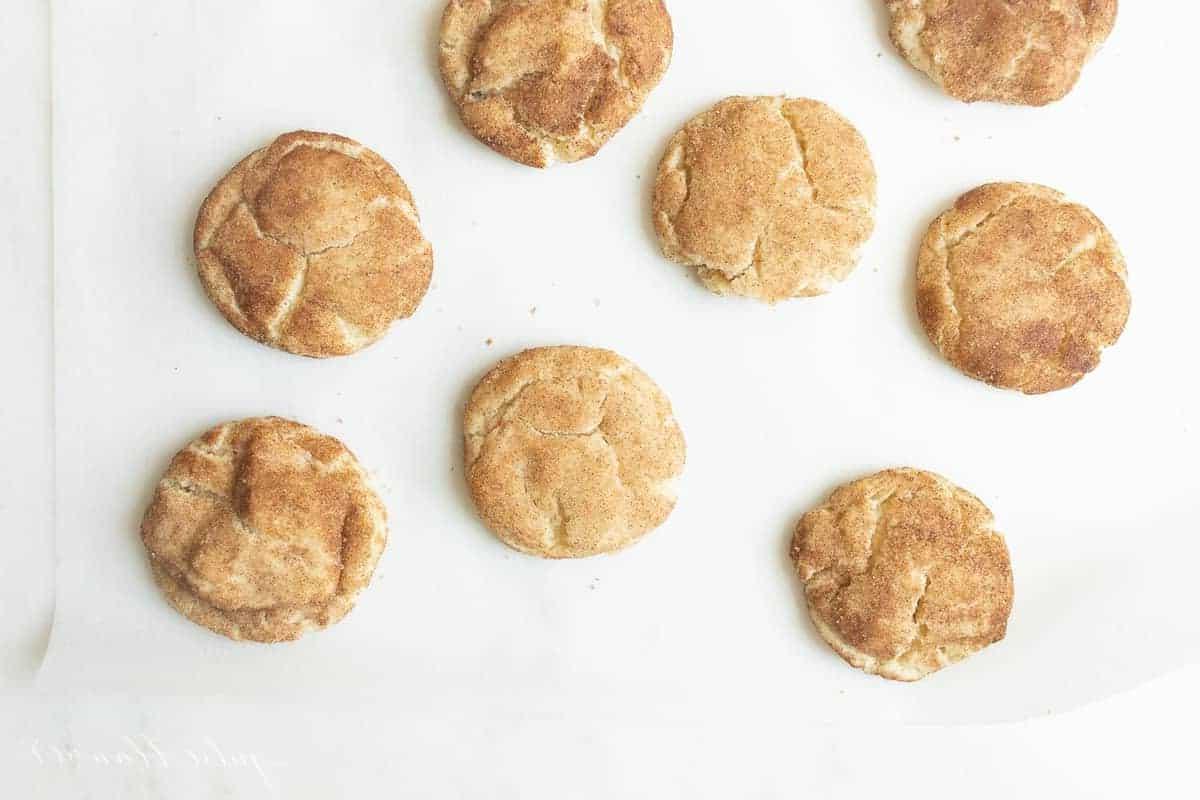 Die besten weichen Snickerdoodles 7 Snickerdoodle-Kekse auf einer weißen Oberfläche.