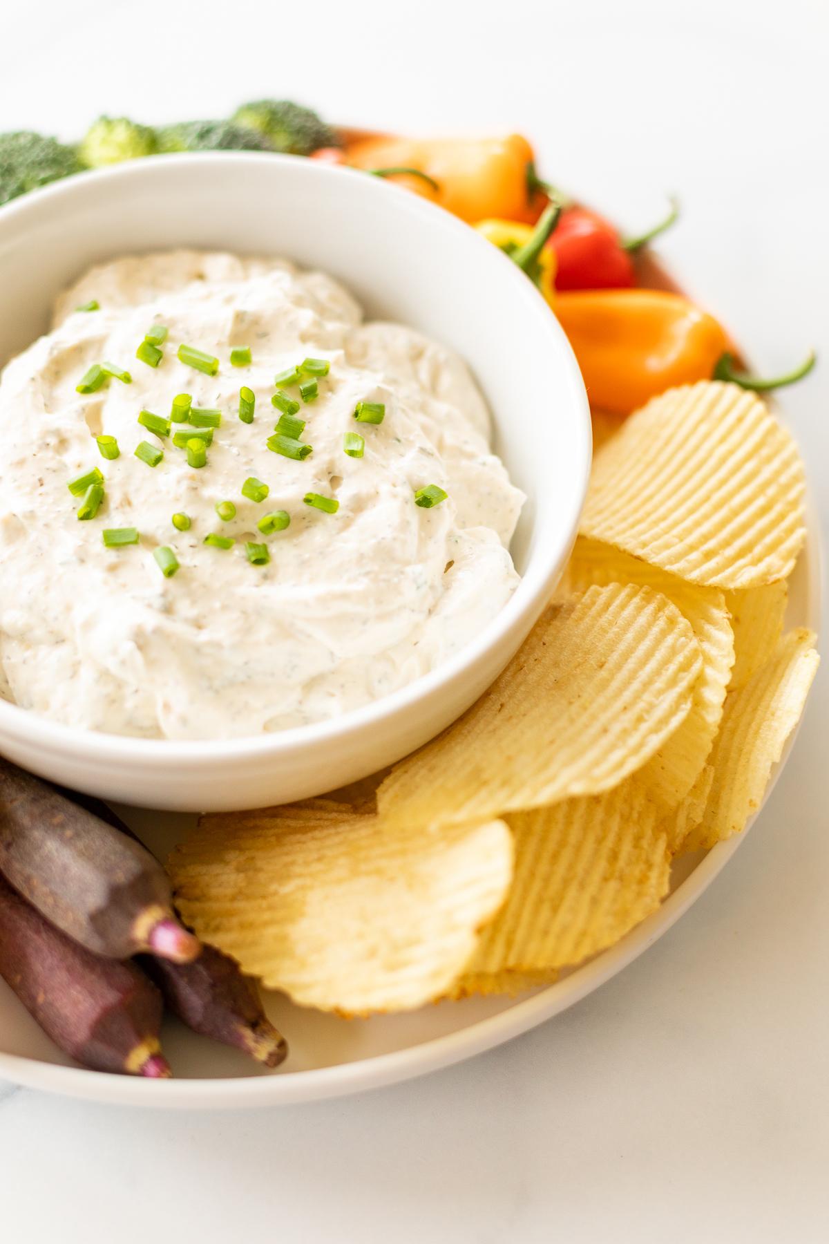 Ranch-Dip 7 Eine Schüssel Ranch Dip, garniert mit frischem Schnittlauch, auf einer Platte mit Chips und Gemüse.