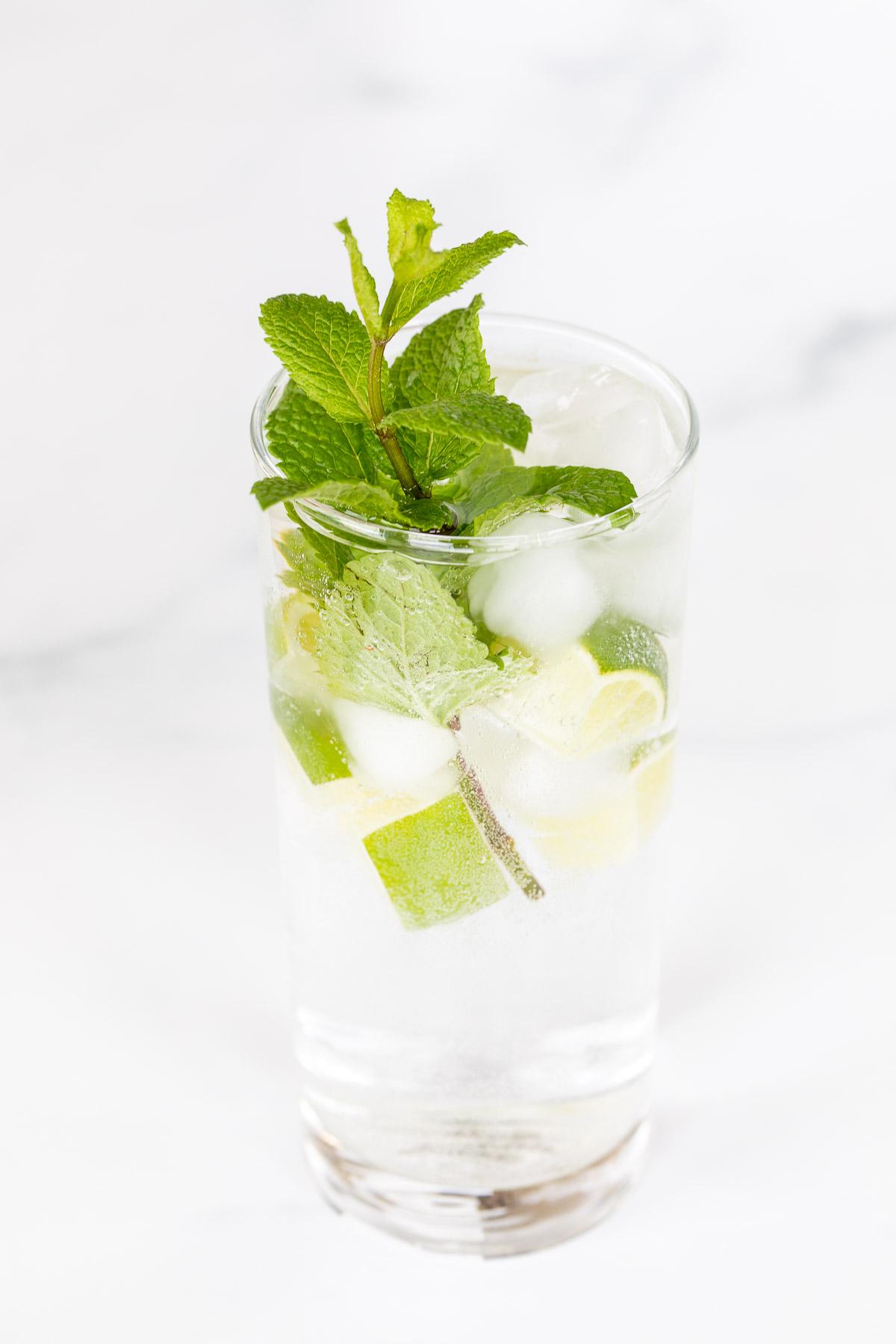 Alkoholfreier Mojito 7 Ein klares Glas voll mit einem Virgin Mojito auf einer Marmoroberfläche.