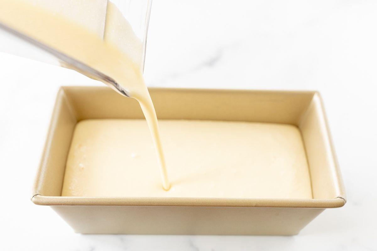 Flüssiges Orangen-Sherbet wird vor dem Einfrieren in eine goldene Brotkastenform gegossen