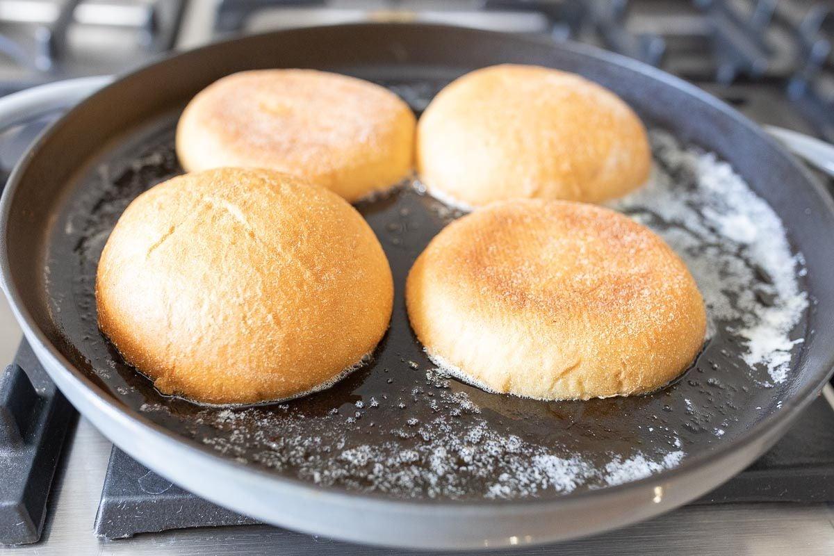 Burger Buns in einer Gusseisenpfanne mit geschmolzener Butter toasten