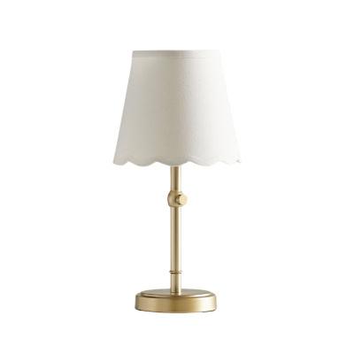 Pottery Barn Kids: Der Look zum kleinen Preis 8 Eine Tischlampe aus Messing mit einem weißen Stofflampenschirm, der einen geschwungenen Rand aufweist, bietet eine schicke, raffinierte Atmosphäre, die an den Pottery Barn Kids Look for Less erinnert.