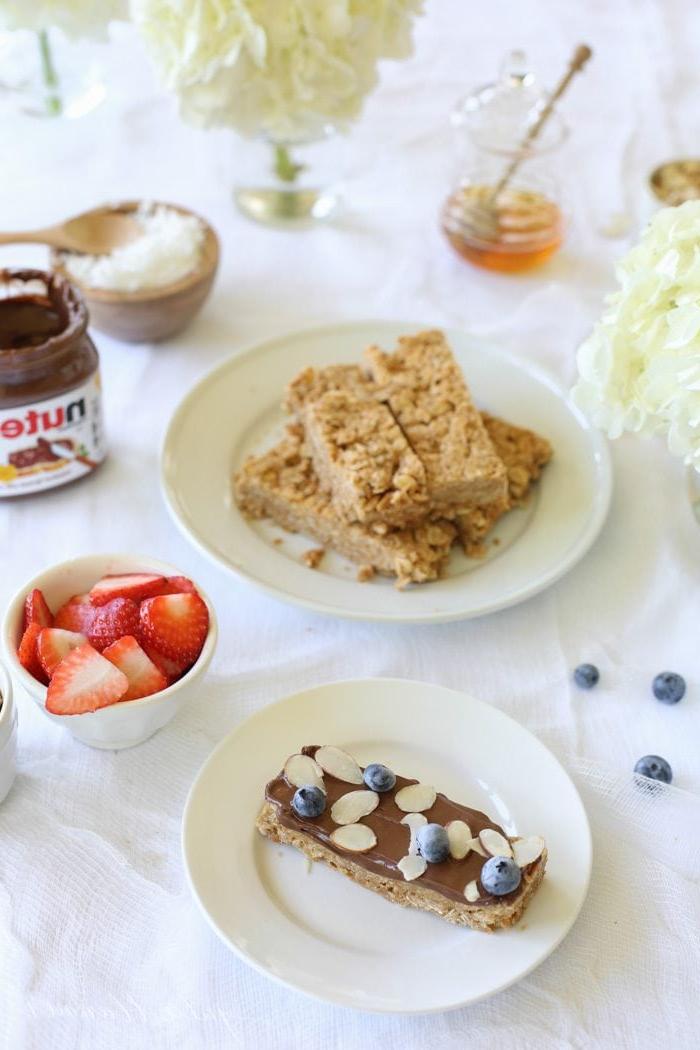 Lernen Sie, wie Sie köstliche Granola Riegel ohne Backen in nur 10 Minuten mit nur 4 Zutaten zubereiten! Diese Erdnussbutter Granola Riegel sind ein köstliches Frühstück! Erdnussbutter Granola Riegel neben Schalen mit verschiedenen Toppings.