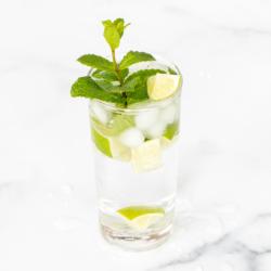 Alkoholfreier Mojito 8 Ein klares Glas voll mit einem Virgin Mojito auf einer Marmoroberfläche.