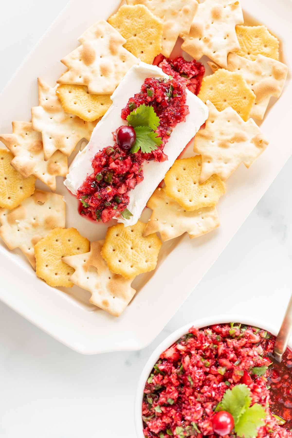 Cranberry-Salsa 8 Ein Teller voller Cracker, die Cranberry-Salsa auf einem Block Frischkäse umgeben