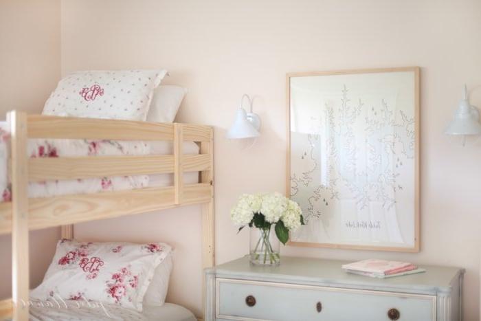 Mädchenetagenbett 9 Ein zartrosa Schlafzimmer mit Massivholz-Etagenbetten und femininer rosa floraler Bettwäsche.