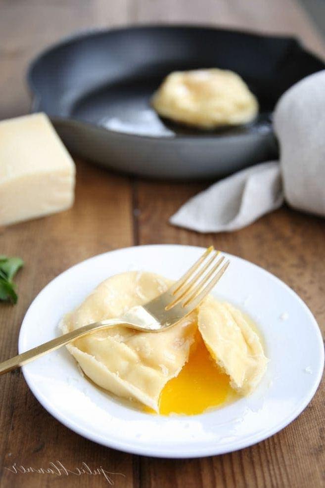 Hausgemachte Eier-Ravioli sind schnell und einfach zuzubereiten und eignen sich hervorragend als Vorspeise oder Hauptgericht. Ravioli gefüllt mit Käse und einem Eigelb, das einfach so beeindruckend ist. Eier-Ravioli auf einem weißen Teller, eine Gabel taucht in das Gericht, und das Eigelb fließt verlockend heraus.