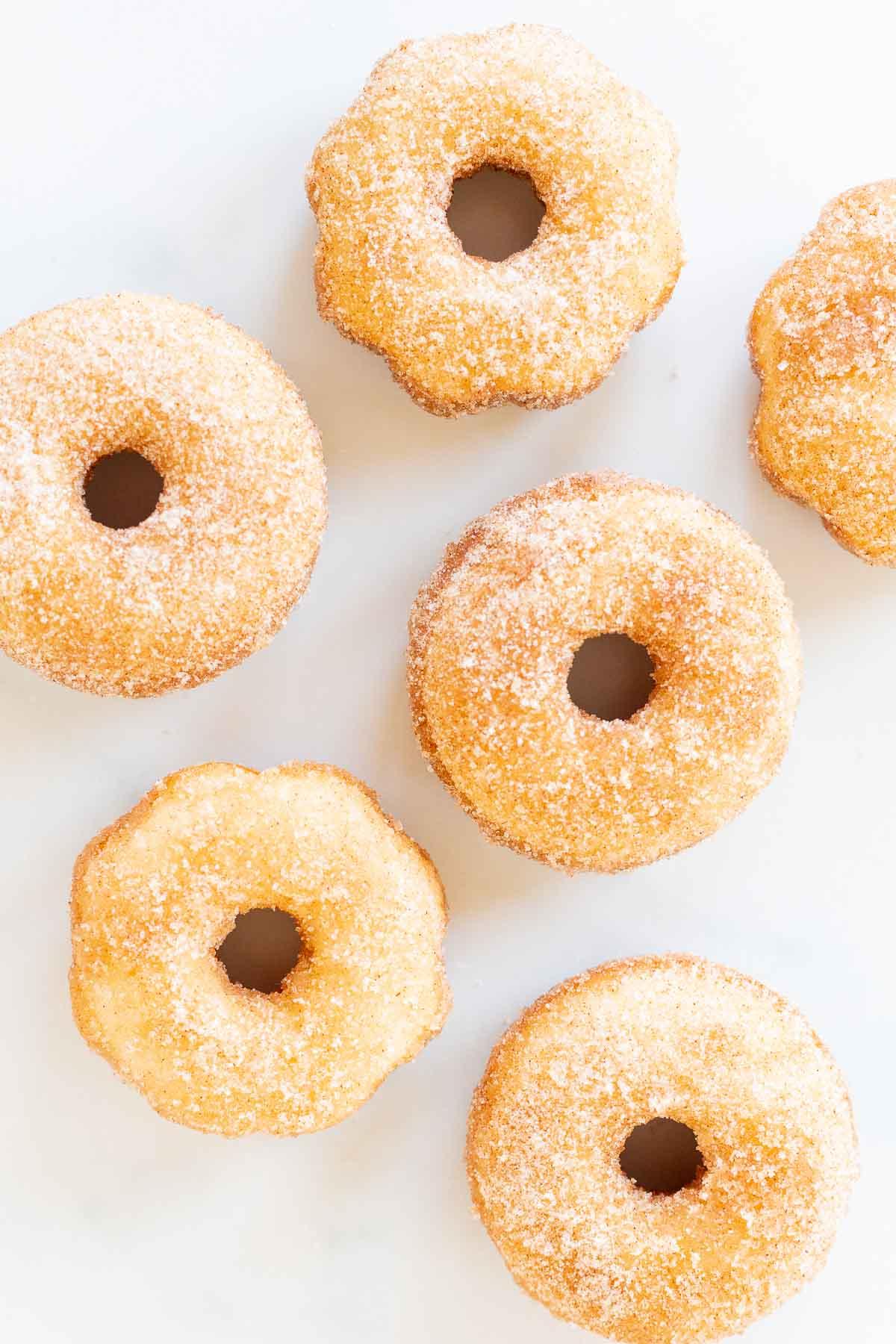 Muttertags-Brunch-Ideen 9 Fünf gezuckerte Donuts auf einer weißen Oberfläche für den Muttertagsbrunch.