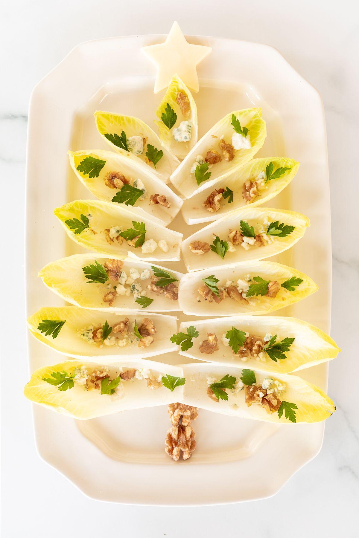 Hand-Endiviensalat 9 Ein Chicorée-Salat in Form eines Weihnachtsbaums auf einer weißen Platte angerichtet.
