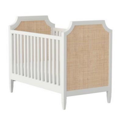 Pottery Barn Kids: Der Look zum kleinen Preis 10 Ein weißes Babybett mit Rattan-Kopfteil, das den stilvollen Pottery Barn Kids Look nachahmt.