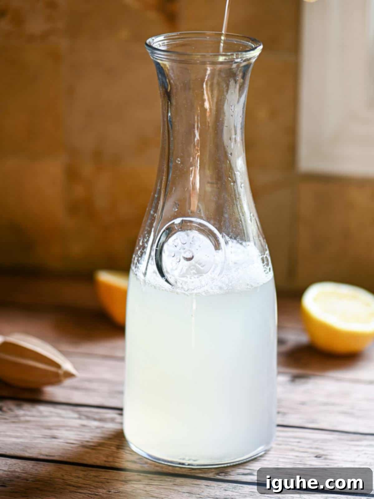 Signature Lavender Lemonade 8 A pitcher filled with lemonade on a wooden table.