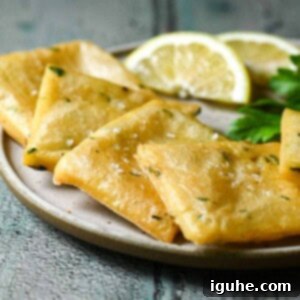 Crispy Sicilian Panelle 11 Close-up of panelle on a beige plate with lemon wedges.
