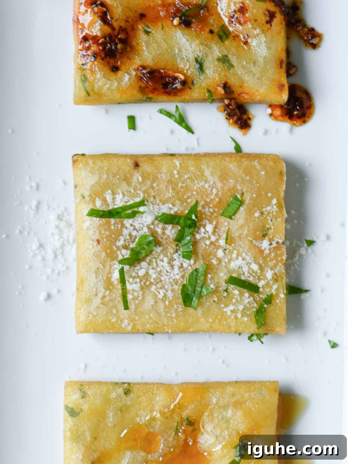 Crispy Sicilian Panelle 9 Three square pieces of chickpea fritters on a white plate.
