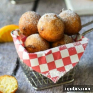 Italian Orange Ricotta Doughnuts 9 Ricotta doughnuts in a fry basket with a red checkered liner.