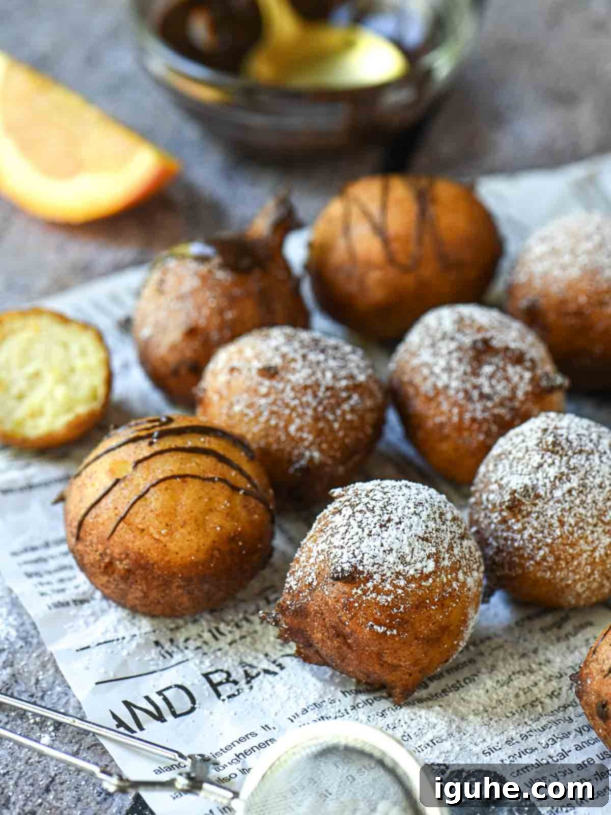 Italian Orange Ricotta Doughnuts 8 Orange ricotta donuts on parchment paper with powdered sugar.