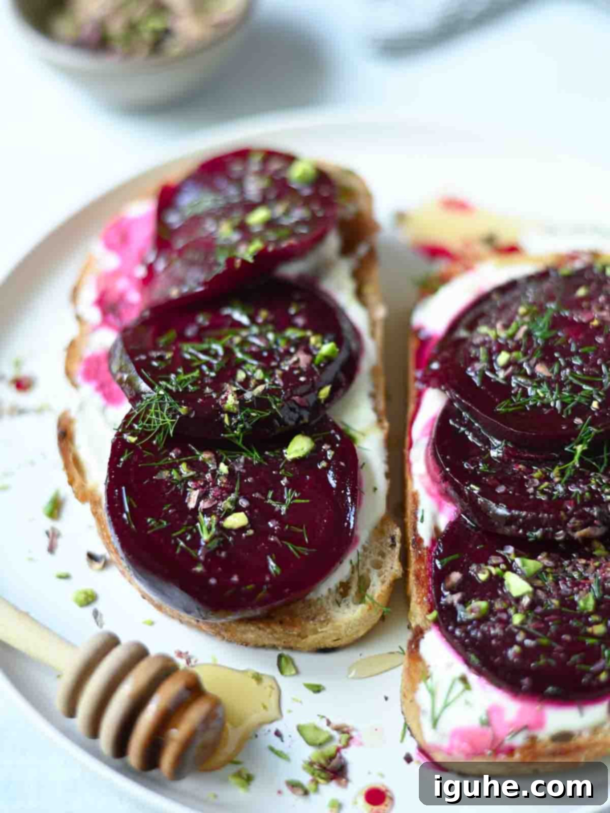 Beet slices on toast with creme Fraiche and dill, artfully arranged on a plate.