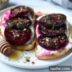 Crimson Beet Toast with Herbed Creme Fraiche 8 Eye-level view of artistically sliced beets on toast with fresh dill and crunchy pistachios.
