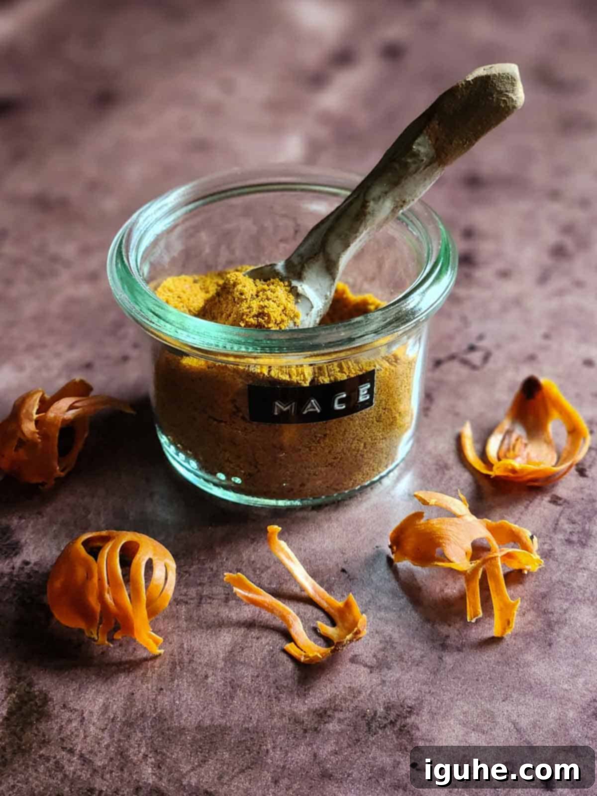 Delightful Mace Spiced Bundt Bites 3 Ground mace in a clear jar and blade mace on a brown surface.