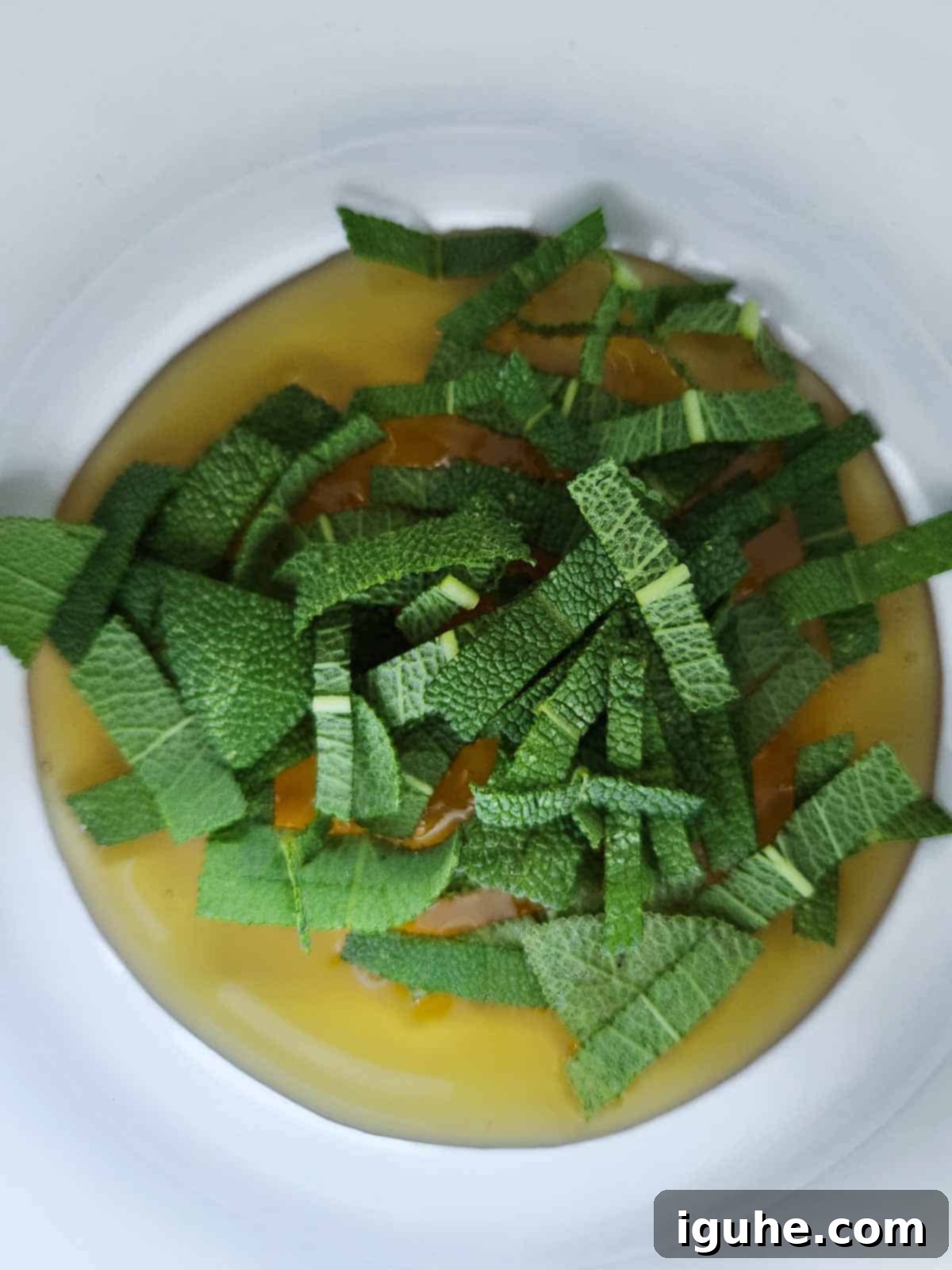 Creamy Ricotta Apple Toast with Sage-Kissed Honey 4 Fresh sage leaves steeping in warm honey in a small saucepan.