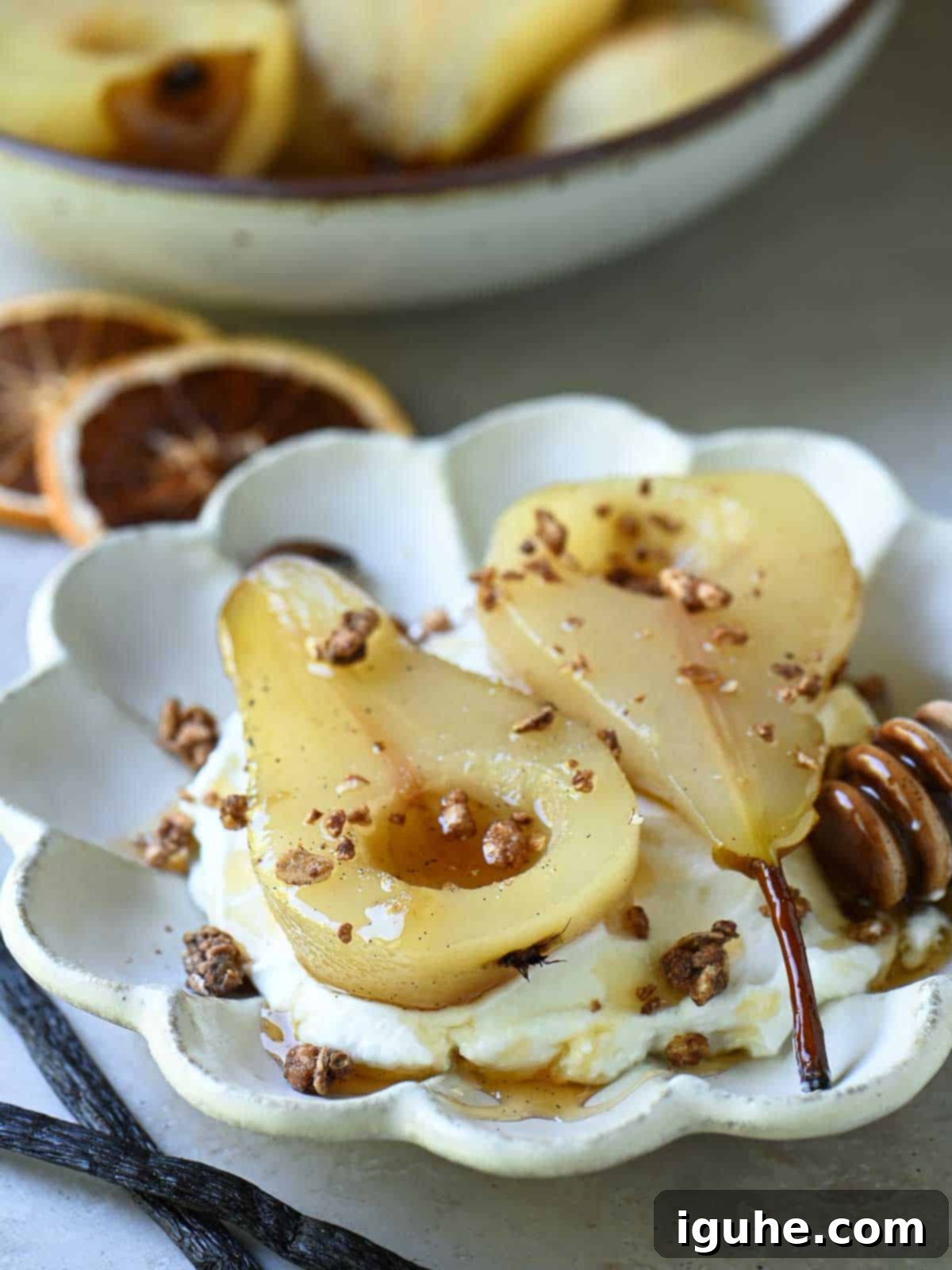 Velvet Vanilla Pears with Creamy Yogurt 3 Poached pears in a flower plate with granola.