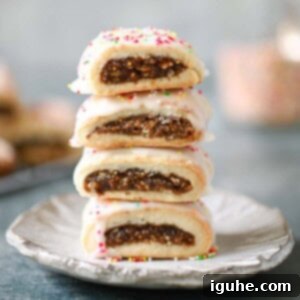 Sicilian Cuccidati Festive Fig Cookies 11 A stack of 4 beautifully glazed and sprinkled cuccidati on a small plate.