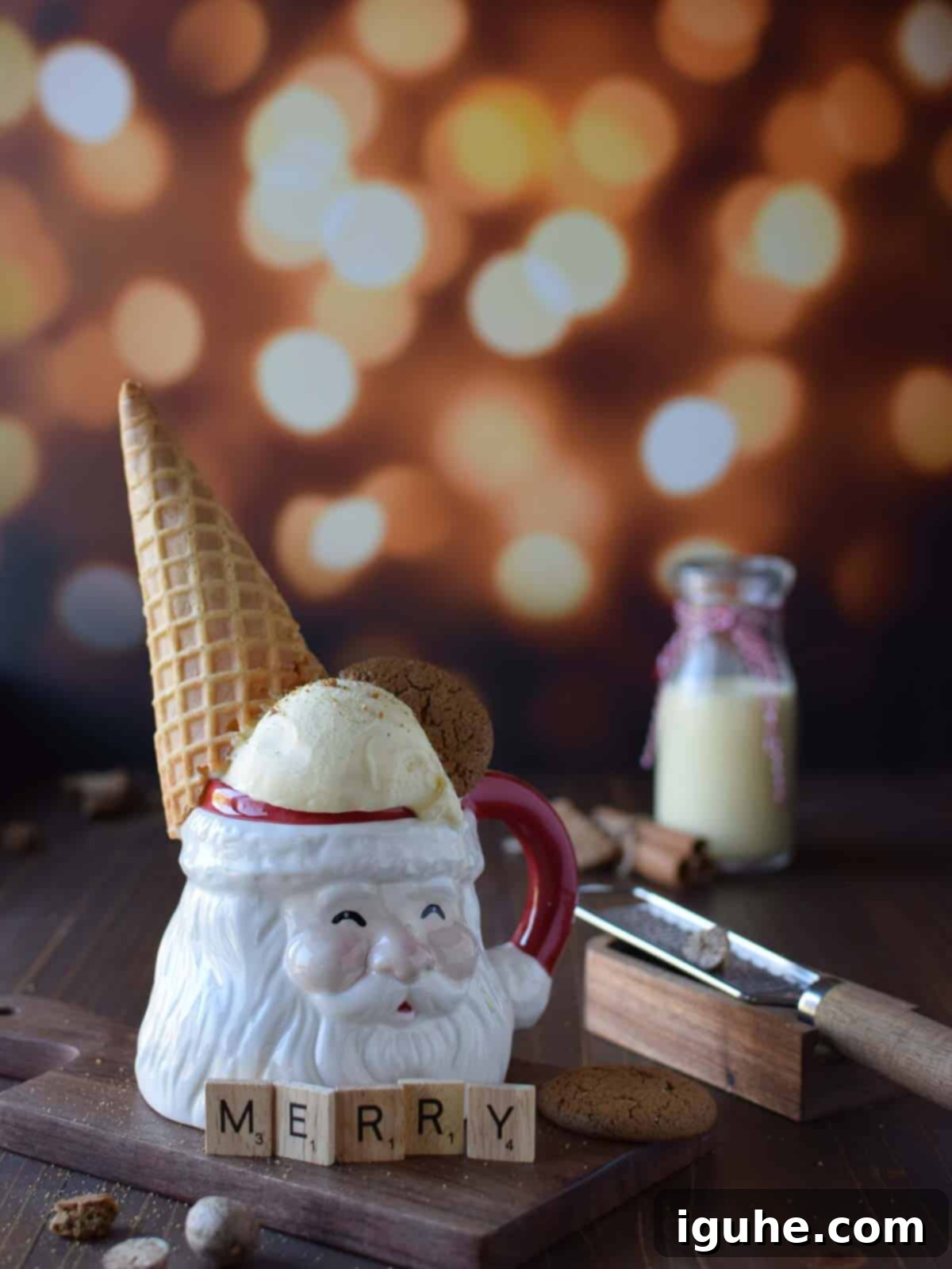 Festive Eggnog Dream Ice Cream 2 Eye level view of egg nog ice cream in a santa claus mug with a cone on it's head on brown surface with glittery background