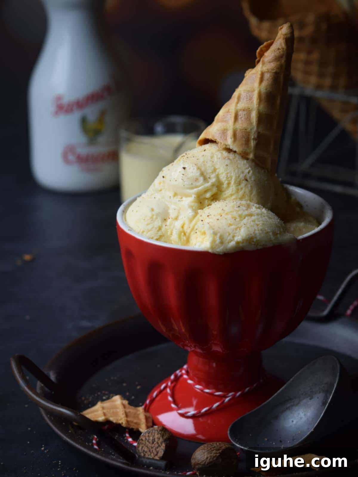 Festive Eggnog Dream Ice Cream 8 Ice cream in a red cup with an ice cream cone on top.
