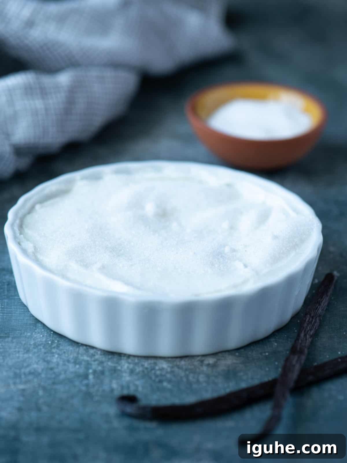 Effortless Vanilla Yogurt Brulee 4 Sugar sprinkled over vanilla yogurt in a white ramekin.
