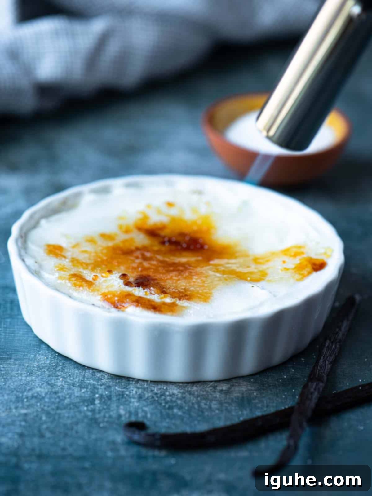 Effortless Vanilla Yogurt Brulee 5 A flame sweeping over sugar to harden it for yogurt brulee in a ramekin.