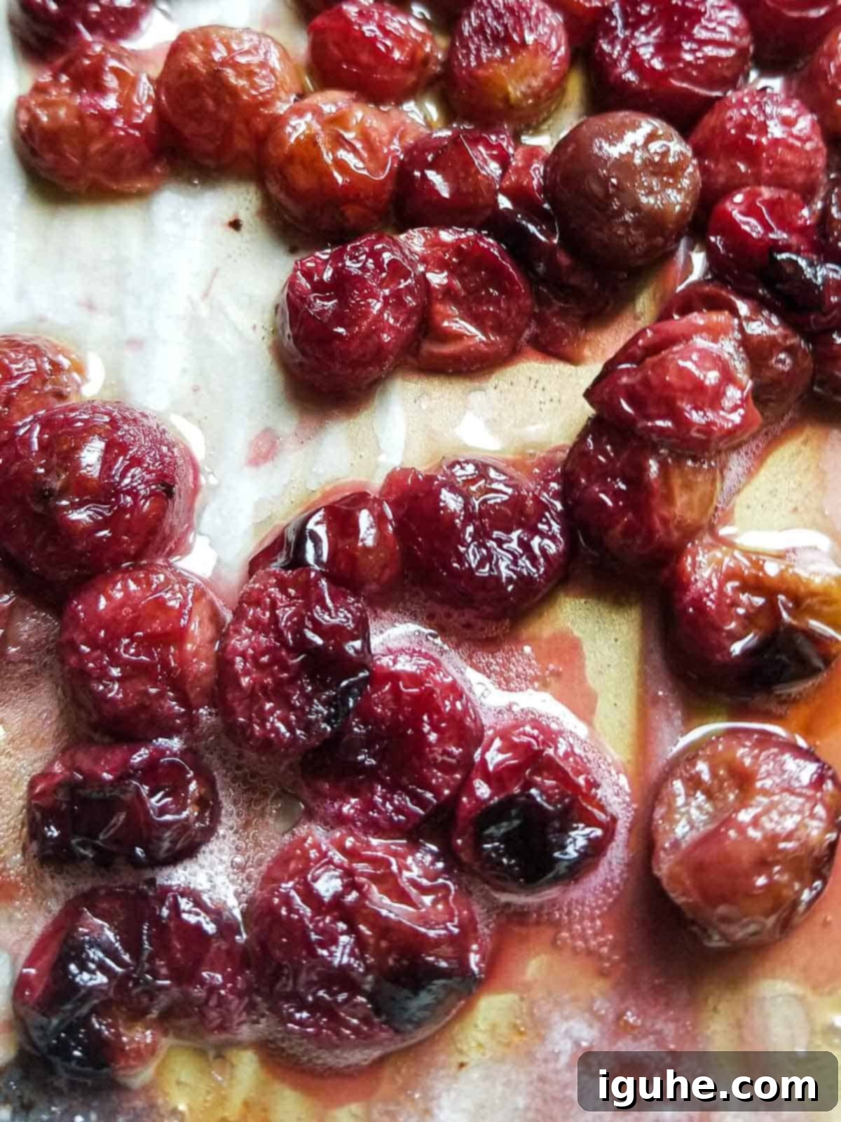 Roasted Grape Rotisserie Chicken Salad 5 Over head view od oven roasted red grapes right out of the oven on a pan lined with parchment paper