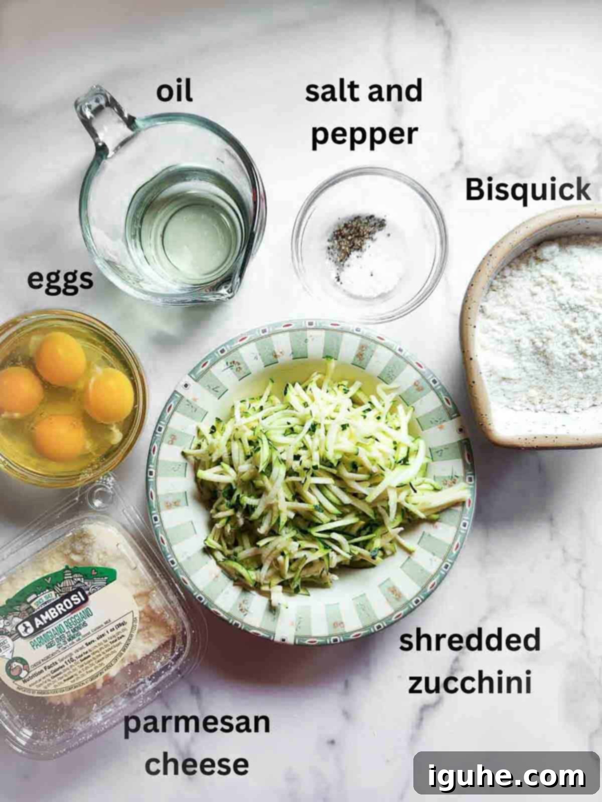 Naked Zucchini Quiche 3 Fresh ingredients for crustless zucchini pie, including shredded zucchini, eggs, and various cheeses, beautifully arranged on a white marble board.