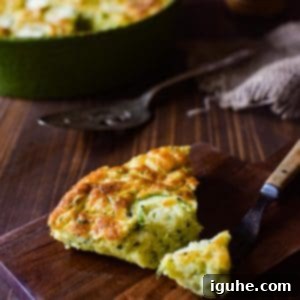 Naked Zucchini Quiche 8 A delectable slice of golden-brown crustless zucchini pie, with a fork poised to take a bite, presented on a rustic wooden cutting board.