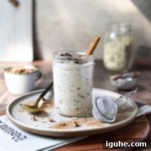 Creamy Maple Raisin Overnight Oats 10 Eye-level view of overnight oats in a jar on a wood surface with the Sunday paper showing.