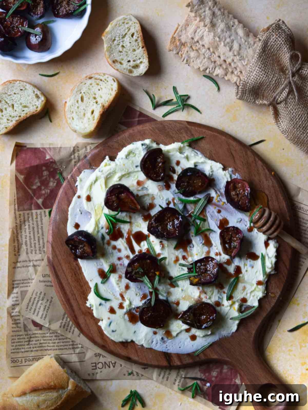 Overhead view of a beautifully arranged roasted fig and rosemary butter board, ready for serving with fresh bread slices.