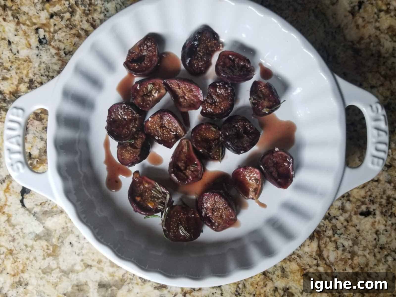 Aromatic Roasted Fig and Rosemary Butter Board 4 Perfectly roasted figs out of the oven in a white baking pan, glistening with syrupy sauce, ready to cool.