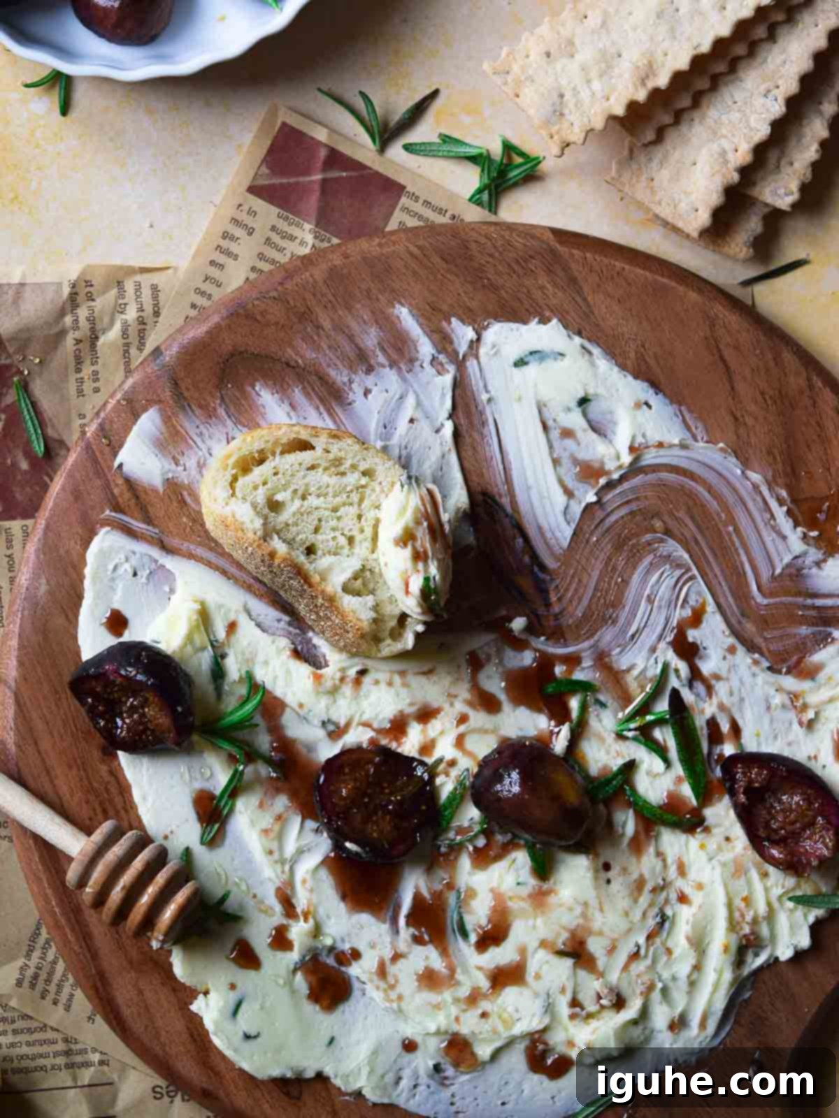 Aromatic Roasted Fig and Rosemary Butter Board 6 Overhead view of a roasted fig and rosemary butter board with crusty bread slices and a butter knife, ready for serving.