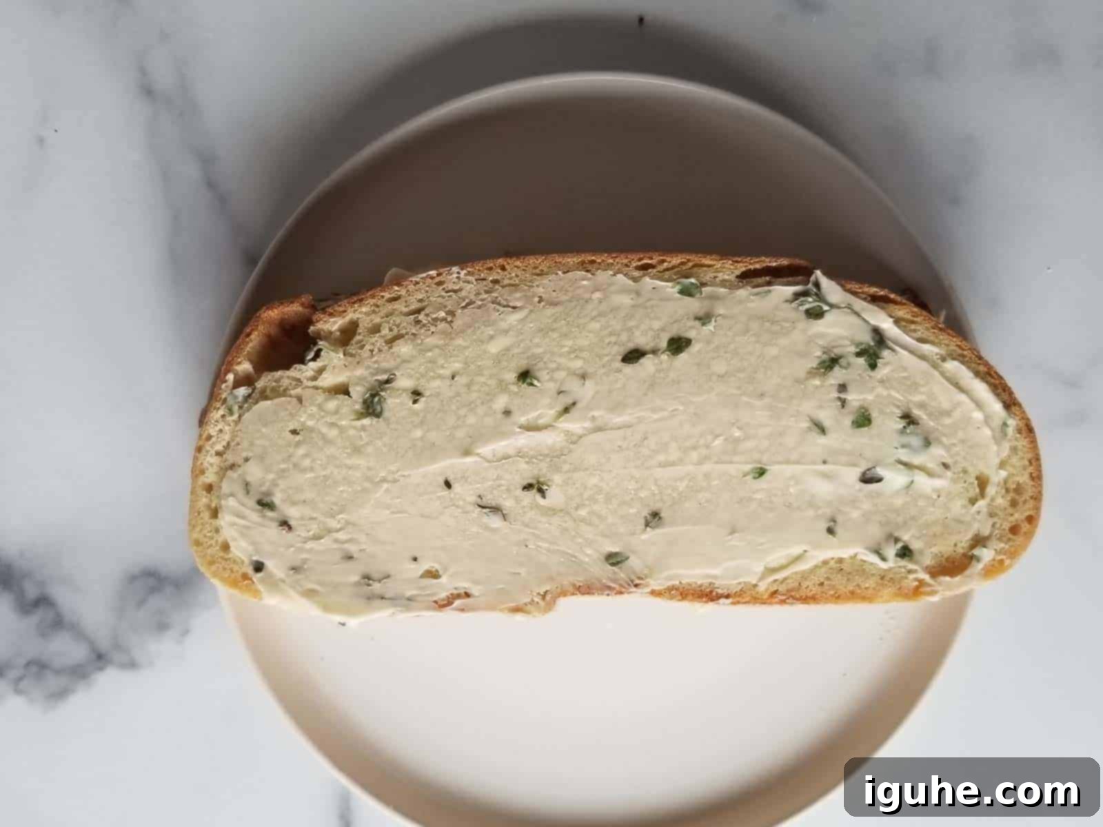 Sweet Pear and Pungent Gorgonzola Grilled Cheese 7 Bread spread with thyme butter ready to be grilled.