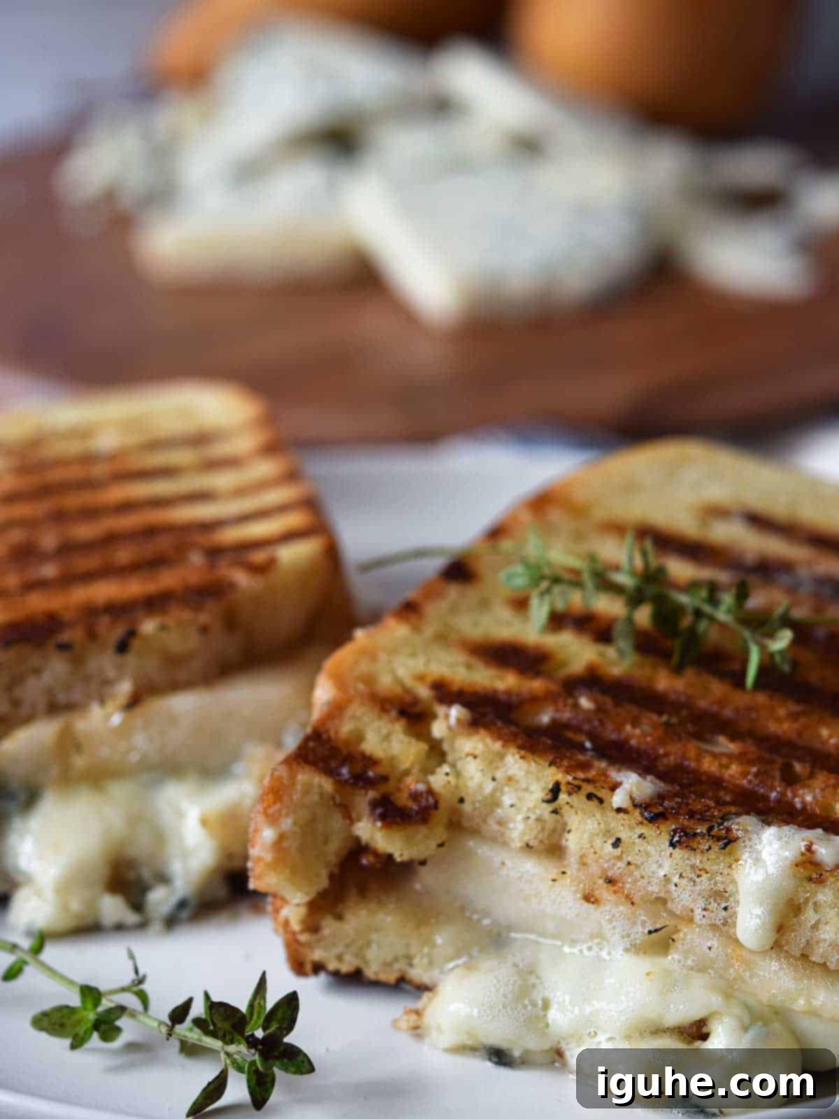 Sweet Pear and Pungent Gorgonzola Grilled Cheese 8 Gorgonzola grilled cheese cut in half on a white plate.